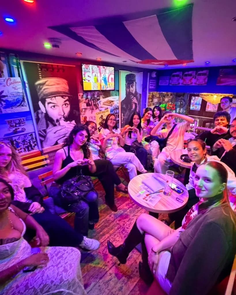 Fuse residents around the tables at Tropic in Gozsdu Udvar, several making heart shapes with their hands